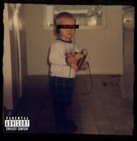 a child is standing in a kitchen holding a cd